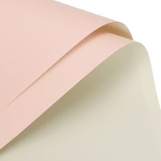 a sheet of pink paper on top of a white surface with the corner cut out