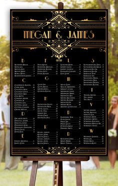 a black and gold wedding seating chart on an easel in front of some people