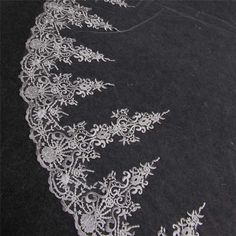 white lace on black fabric with flowers and leaves