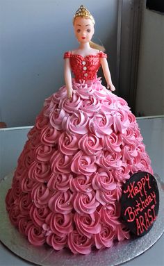 a birthday cake made to look like a princess in a pink dress with roses on it