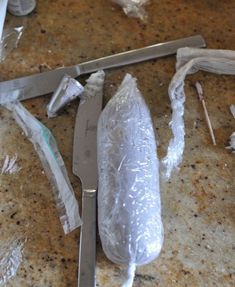 a knife and some plastic wrap on a counter