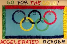 a bulletin board with the olympic rings and numbers on it that says go for the gold