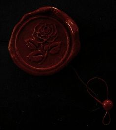 a wax stamp with a rose on it and a string attached to the rubber pad