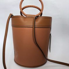 Leather Bucket Bag Tan Bucket Shoulder Bag With Removable Pouch, Designer Tan Bucket Bag For Everyday, Tan Leather Handle Bucket Shoulder Bag, Designer Textured Leather Bucket Bag For Shopping, Brown Calf Leather Bucket Bag With Gold-tone Hardware, Designer Bucket Shoulder Bag With Leather Lining, Brown Calf Leather Bucket Bag, Designer Leather Bucket Shoulder Bag, Chic Brown Bucket Bag With Leather Lining