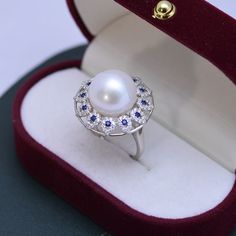 House of Pearls Boutique presents a timeless and luxurious pearl ring. Crafted with a 13-14mm Freshwater Pearl, adorned with a blue gemstone, this AAAA ring is truly an exquisite piece. Wear it for your special day or for an elegant evening look. Perfect for bridal parties and special occasions, the Luxury Ring-AAAA allows you to stand out from the crowd in style. Add a touch of extravagance to your jewelry collection and make memories that will last a lifetime. White 13-14mm Freshwater Pearl Ri Luxury Oval Pearl Ring, Luxury Blue Pearl Jewelry, Exquisite Akoya Pearl Ring, Luxury Akoya Pearl Ring, Elegant Sterling Silver Cabochon Pearl Ring, Elegant Pearl Ring With Birthstone For Gifts, Elegant Pearl Ring With Birthstone As Gift, Elegant Round Cabochon Pearl Ring, Elegant Pearl Birthstone Ring As Gift