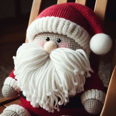 a crocheted santa claus sitting in a rocking chair with his hat and beard