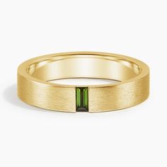 a yellow gold wedding band with a green tourmaline stone in the center, on a white background