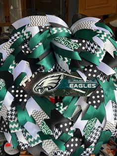 a wreath made out of green and white ribbon with the philadelphia eagles logo on it