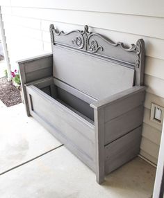 a gray bench sitting on the side of a house