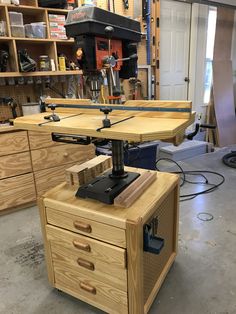 a workbench in a garage with tools on the table and drawers behind it