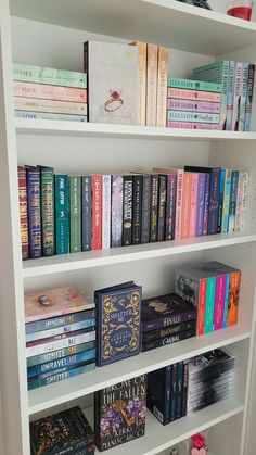 a book shelf filled with lots of books on top of white shelving unit units