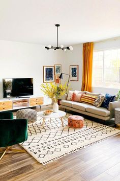 a living room filled with furniture and a flat screen tv on top of a wooden table