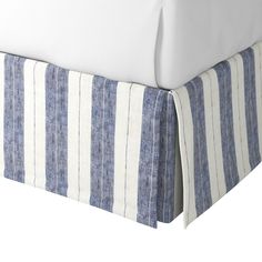 a bed with blue and white striped bedspread next to a pillow on top of it