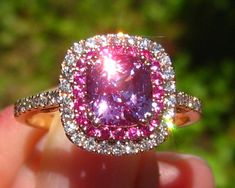 A beautiful and sparkly engagement ring featuring an amazing pink sapphire, surrounded by more pink sapphires, in a rose gold diamond double halo. The center stone is a beautiful precision-cut cushion pink sapphire, measuring 1.88 carats and 6.9x6.3mm. It is basic heat and comes from Madagascar. It has a juicy pink color, clean crystal and crazy sparkle (be sure to check the video). Great choice for a one-of-a-kind engagement ring! The sapphire is set in a 14K rose gold diamond double-halo ring, Luxury Pink Halo Ring For Wedding, Pink Halo Ring In Fine Jewelry Style, Pink Halo Ring Fine Jewelry, Luxury Pink Halo Ring For Gift, Luxury Pink Halo Ring As Gift, Pink Sapphire Jewelry With Halo Design, Pink Halo Design Jewelry, Elegant Pink Jewelry With Halo Design, Luxury Pink Halo Design Jewelry