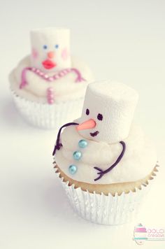 two cupcakes with frosting on them are decorated like snowmen