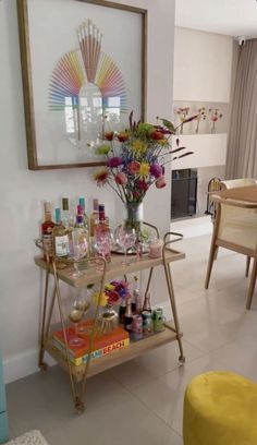 a living room filled with furniture and a table covered in bottles, glasses and flowers