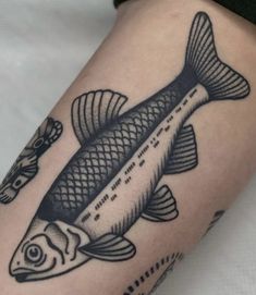 a black and white fish tattoo on the arm