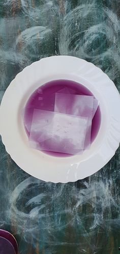 a white plate with purple liquid in it