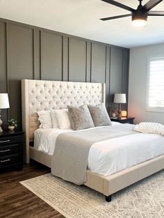 a bedroom with a bed, nightstands and ceiling fan in the middle of it