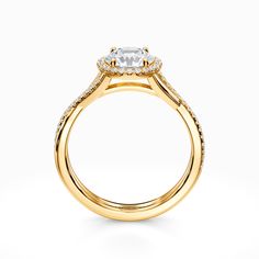 a yellow gold engagement ring with an oval cut diamond center and pave set shoulders