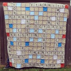 a blanket with words written on it sitting in front of a wooden fence and grass