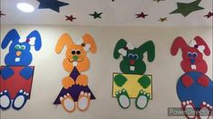 the wall is decorated with colorful paper cut outs and stars above it are four rabbits