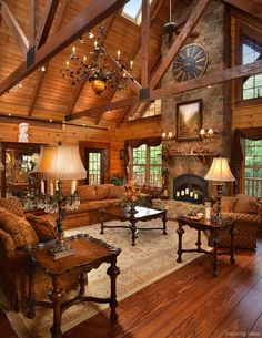 a living room filled with lots of furniture and a clock mounted to the wall above it