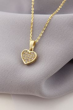 Adorn yourself with elegance and love with our enchanting Gold Heart Pendant Necklace. This dazzling piece features intricate details and sparkling stones that capture the essence of romance and charm. The heart-shaped pendant exudes a sense of sentiment and beauty, making it a perfect accessory to express your affection for someone special. Whether it's a gift for yourself or a loved one, this necklace is an ideal choice to celebrate love and emotions. Embrace the magic of this pendant as it shines brightly and gracefully around your neck, adding a touch of sophistication to any outfit. Let this stunning necklace be a symbol of love, a thoughtful gesture for Valentine's Day or any occasion that calls for a meaningful and stylish jewelry piece. Cubic Zirconia Heart Pendant Jewelry With Heart Beads, Sparkling Stone Necklaces For Valentine's Day Gift, Valentine's Day Necklaces With Sparkling Stones As Gifts, Elegant Diamond White Heart Charm Necklace, Valentine's Day Necklace With Sparkling Stones, Valentine's Day Double Heart Jewelry With Sparkling Stones, Valentine's Day Heart Necklace With Sparkling Stones, Valentine's Day Gift Heart Necklace With Sparkling Stones, Valentine's Day Double Heart Sparkling Stones Jewelry