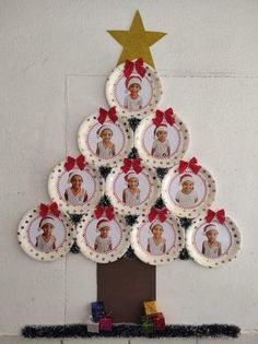 a christmas tree made out of plates with pictures on it's side and gold star