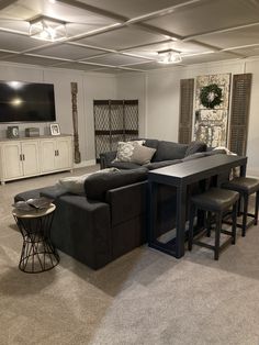 a living room filled with furniture and a flat screen tv mounted on the wall above it