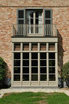 a brick building with two balconies on the second floor and an open balcony