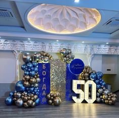 the 50th birthday decorations are in blue and gold colors, with balloons around it that spell out 50