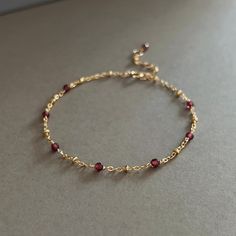 "* DETAILS* This dainty bracelet is a perfect gift to the one you love or to yourself. A nice every day bracelet. - Garnet Faceted Beads 3mm - 14k Gold Filled Chain - 14K GOLD FILLED Wire - 14k Gold Filled Spring Ring Clasp - 14k Gold Filled Link Rings - Bracelet has a 1\" Extension with garnet bead charm. ✨All components are gold filled. 👉🏻For more birthstone bracelets, see https://www.etsy.com/shop/JinnysJewelryBySeJin You may also like 🌟Sapphire Bracelet. https://www.etsy.com/JinnysJewelry Gold Gemstone Bracelet, Dainty Red Jewelry, Garnet Jewellery, Gold Dainty Bracelet, Dainty Red Birthstone Jewelry, Dainty Gold Bracelet With Birthstone, Dainty Bracelets Gold, Gold Garnet Jewelry With Birthstone, Dainty Bracelet