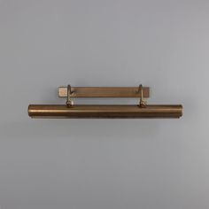 an antique brass towel bar on a gray wall