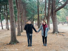 two people are holding hands in the woods