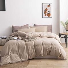 an unmade bed in a room with white walls and wooden floors, along with a wicker basket on the floor