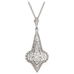 1930's filigree Art Deco pendant necklace. Old Euro center diamond in 14k white gold on a 16 inch 14k white gold chain. Front of the pendant is white gold with a 14k yellow gold back. 1 old euro diamond approx total weight: .10cts G, VS2 Chain length: 16 inches 14k white and yellow gold Length: 1.40 inches or 35.65mm Width: .61 inches or 15.56mm Gold Filigree Necklace, Art Deco Pendant Necklace, Diamond Drop Pendant, Filigree Pendant Necklace, Art Deco Gold, White Gold Pendant Necklace, Filigree Necklaces, Art Deco Pendant, Drop Pendant Necklace