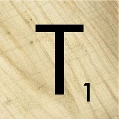 a close up of a piece of wood with the letter t in black on it