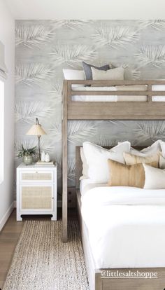 a bedroom with white bedding and palm leaves on the wall