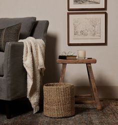 a living room with a gray couch and two pictures on the wall