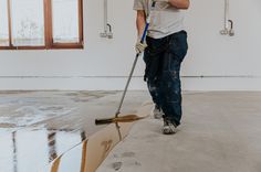 a man is cleaning the floor with a mop