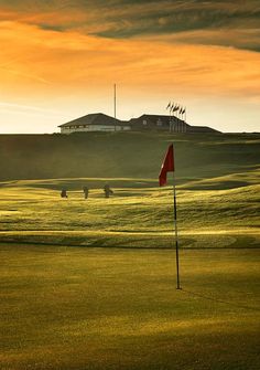 the sun is setting on a golf course