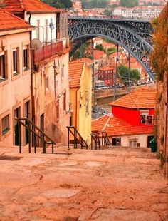 an old city street with buildings and a bridge in the backgroung area