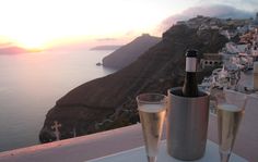 two glasses of champagne on a table overlooking the ocean