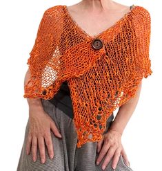 an older woman with her hands on her hips wearing a knitted orange shawl