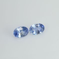 pair of oval blue sapphires on white background