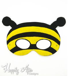 a yellow and black bee mask on a white background