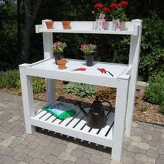 a potting bench with flowers and gardening tools on it