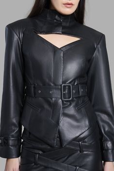 This high-neck faux leather blazer is designed with a chest cut-out, belted sleeves, and a diagonal bottom. The blazer has two pockets and a waist-belt to accentuate your waist. This product is styled with the Black Faux Leather Belted Mini Skirt Fitted Chic Leather Jacket With Belt Loops, Chic Fitted Leather Jacket With Belt Loops, Chic Long Sleeve Leather Jacket With Belt, Fall Party Blazer With Belt, Fitted Belted Leather Jacket For Office, Chic Leather Jacket With Belt For Work, Faux Leather Blazer, Cut Blazer, Belted Mini Skirt