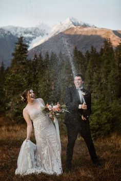 a bride and groom are sprinkling champagne on their wedding day in the mountains